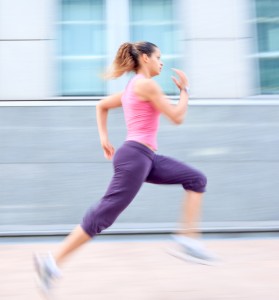 female athlete running in front of a building